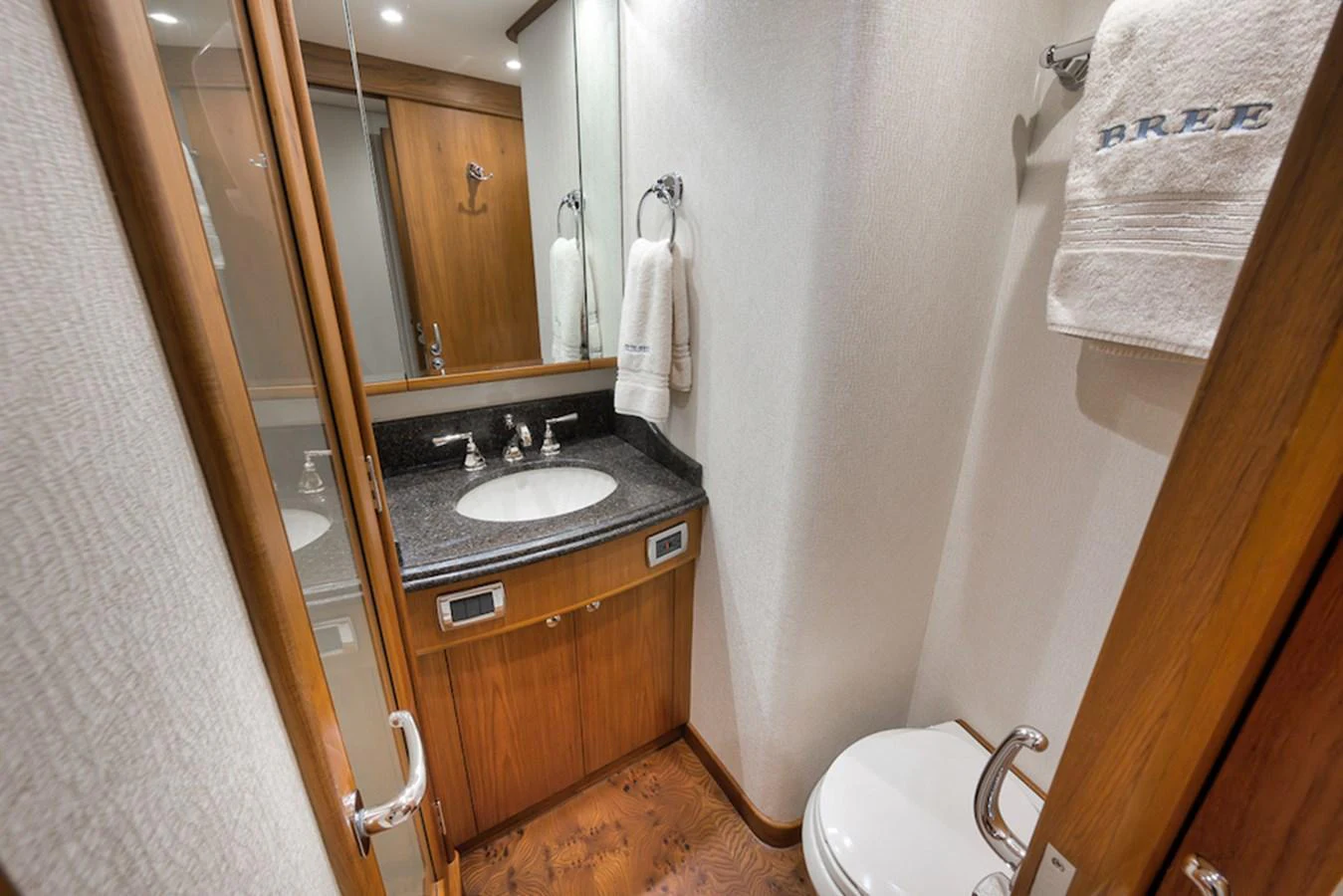 This is a well-appointed yacht bathroom featuring elegant wood finishes and modern fixtures. aboard BREE Yacht for Sale