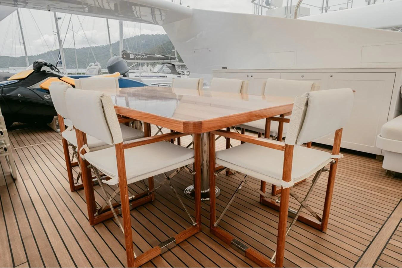 The aft deck features a stylish outdoor dining area with a wooden table and cushioned chairs, perfect for alfresco meals. aboard PARSLEY Yacht for Sale