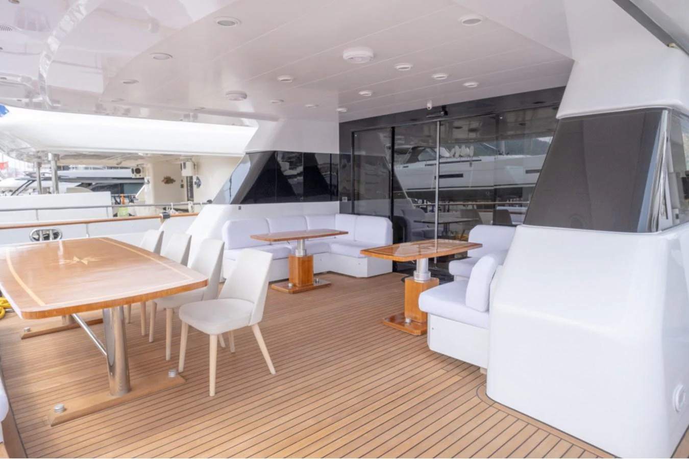 The aft deck features a spacious seating area with elegant wooden tables and comfortable chairs, perfect for alfresco dining. aboard PARSLEY Yacht for Sale