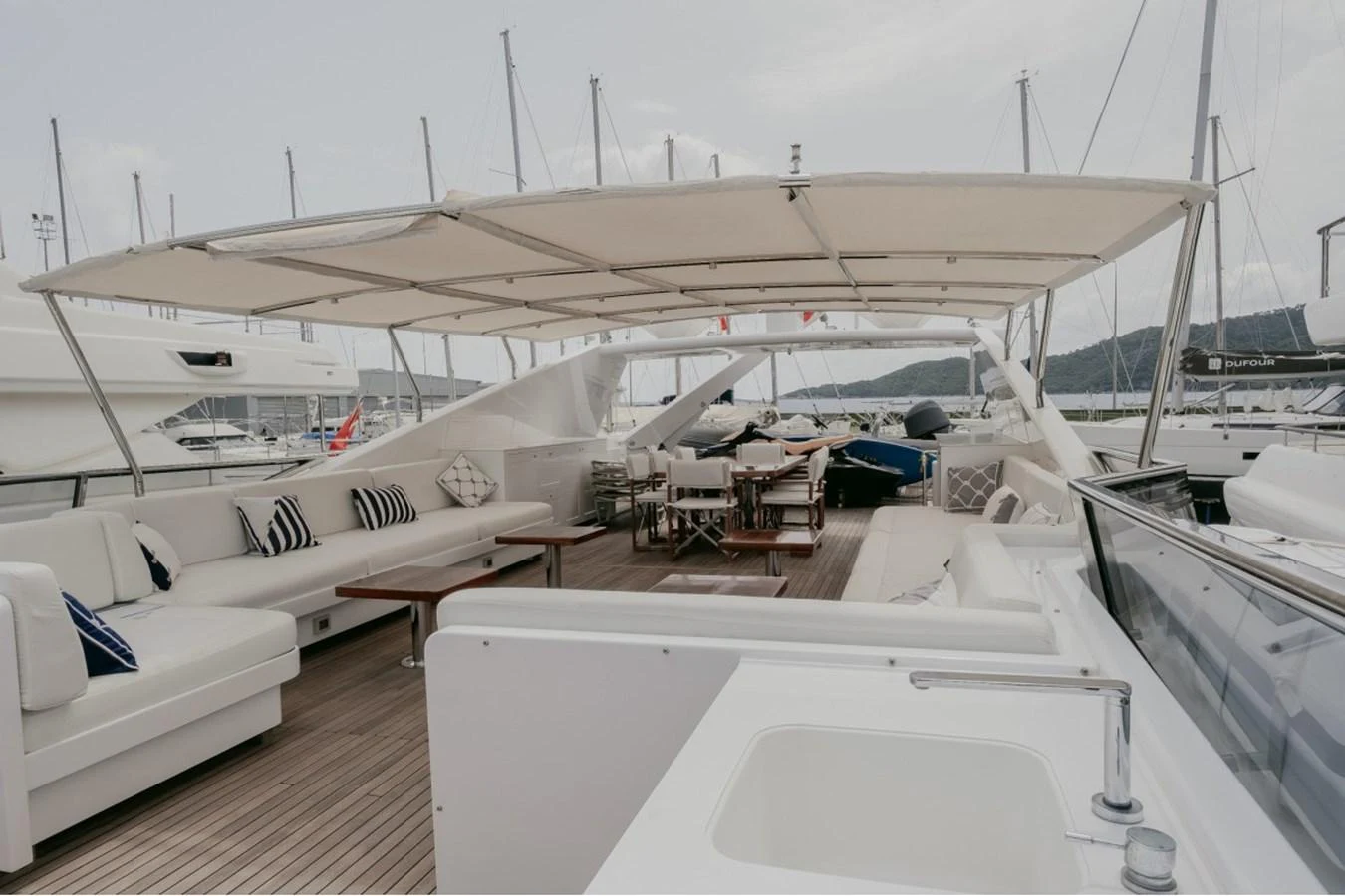 The flybridge offers a spacious and luxurious outdoor seating and dining area under a large canopy. aboard PARSLEY Yacht for Sale