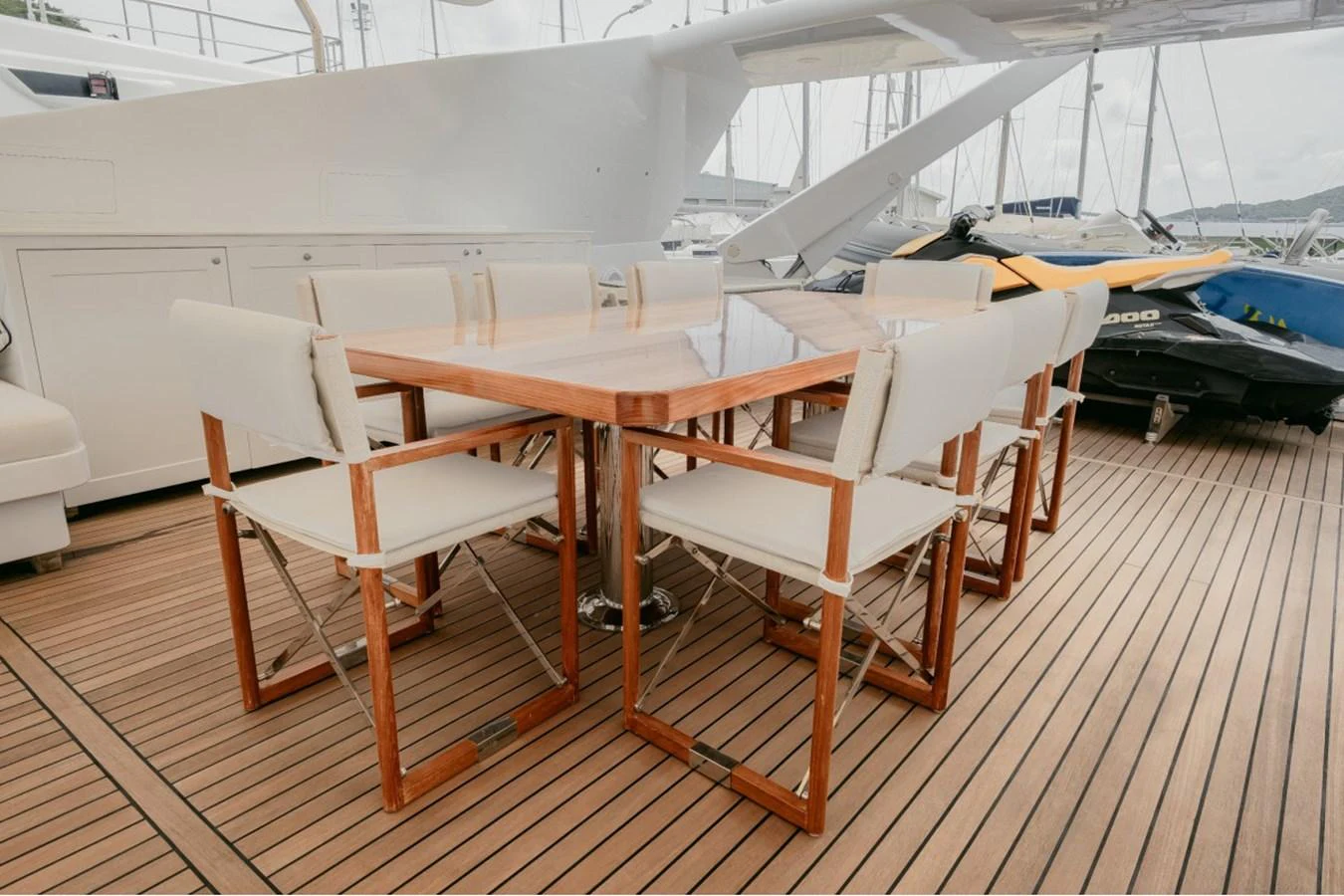 The aft deck features a stylish dining area with a wooden table and comfortable chairs, perfect for alfresco meals. aboard PARSLEY Yacht for Sale