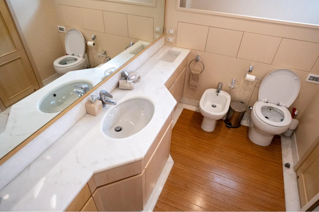 The yacht's bathroom features a sleek design with a marble countertop and wooden flooring. aboard PARSLEY Yacht for Sale