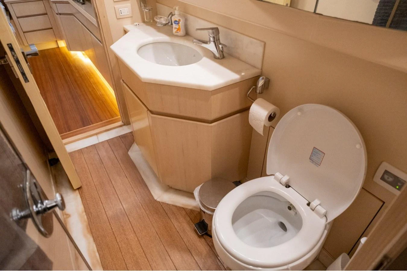 The yacht's bathroom features a modern sink and toilet with elegant wooden flooring. aboard PARSLEY Yacht for Sale