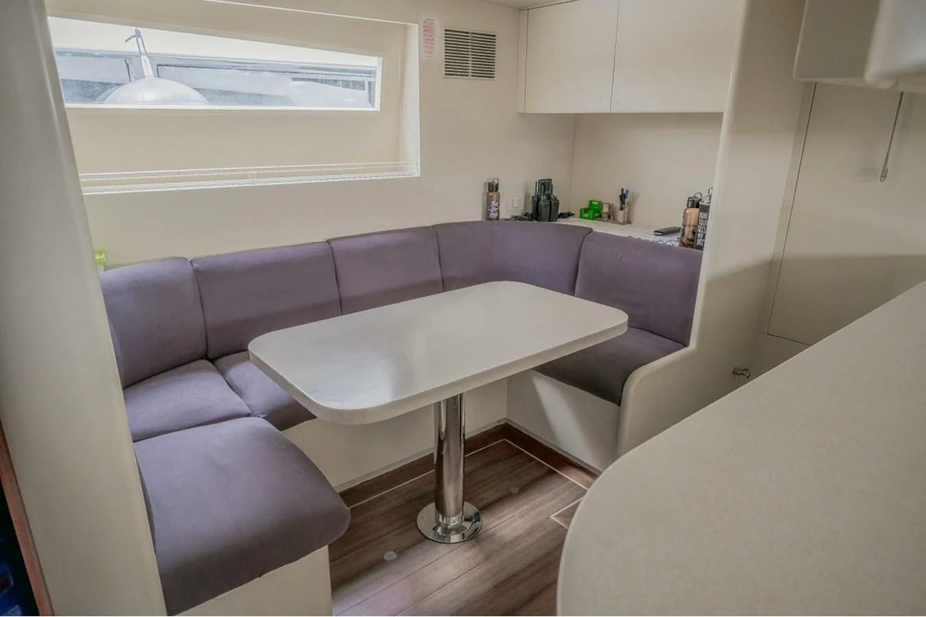 The yacht's interior dining area features a cozy, cushioned seating arrangement around a sleek table. aboard PARSLEY Yacht for Sale