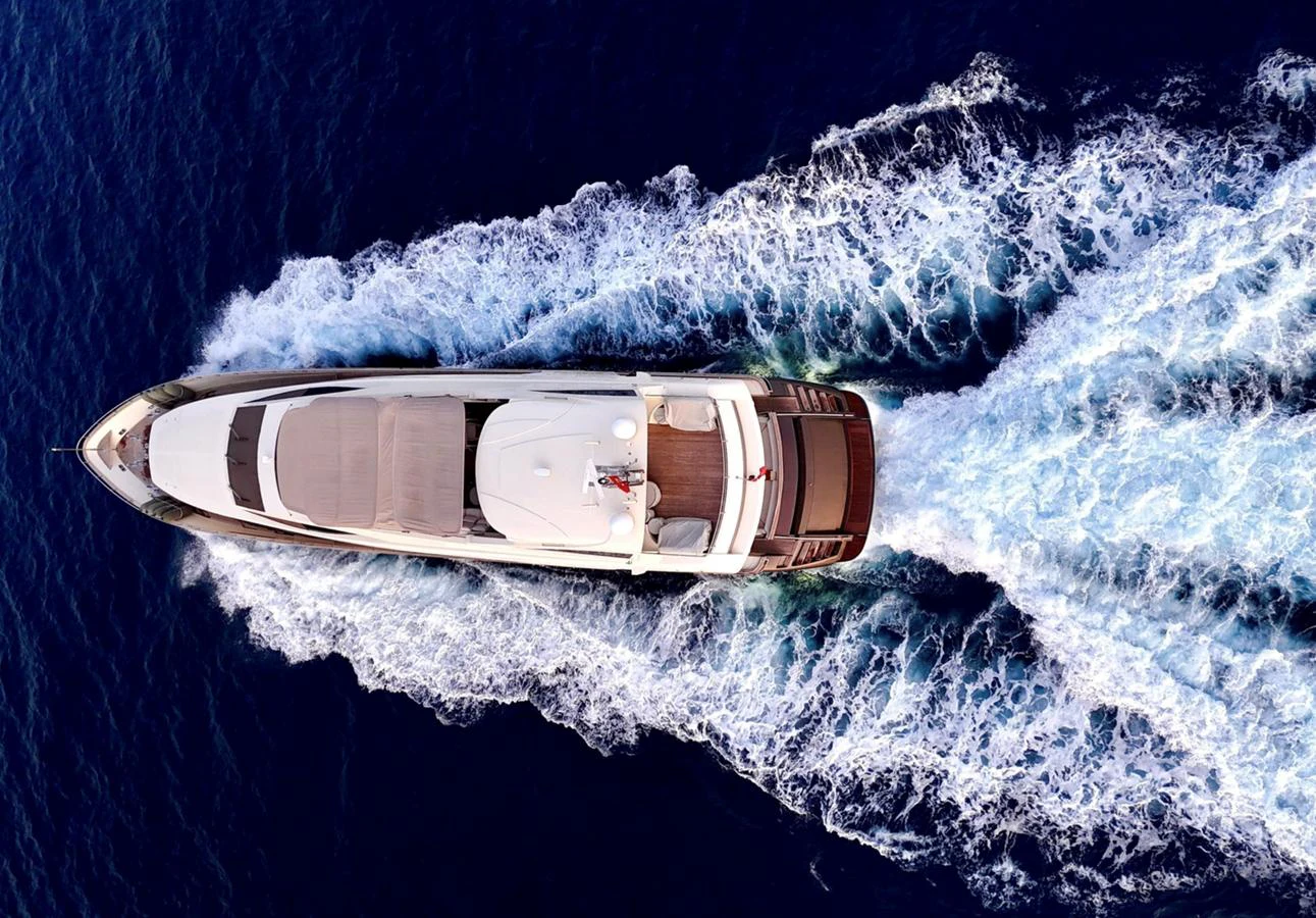 A stunning aerial view of a yacht cruising through deep blue waters, leaving a beautiful wake behind. aboard RIVA 115 Yacht for Sale