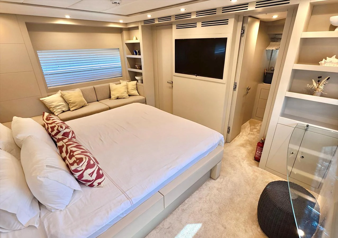 The stateroom features a spacious bed, a cozy seating area, and modern amenities for ultimate comfort. aboard RIVA 115 Yacht for Sale