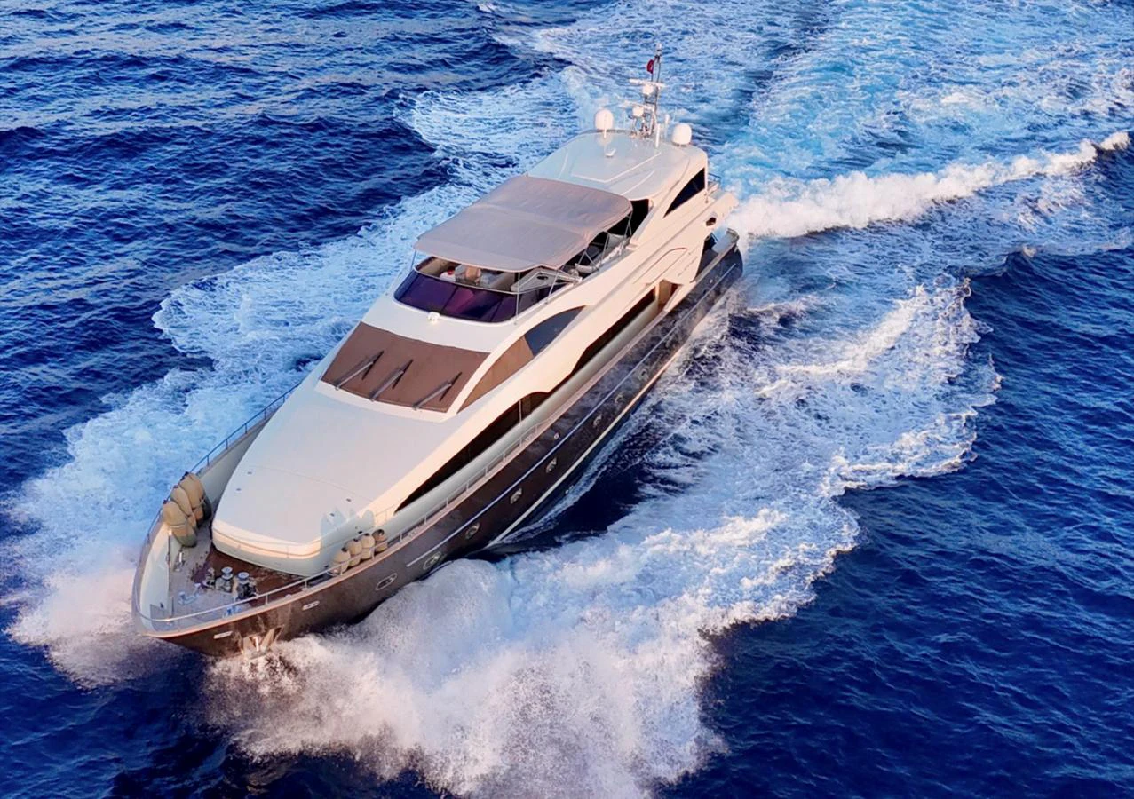 A sleek and modern yacht cruises swiftly through the open sea, leaving a trail of white foam in its wake. aboard RIVA 115 Yacht for Sale