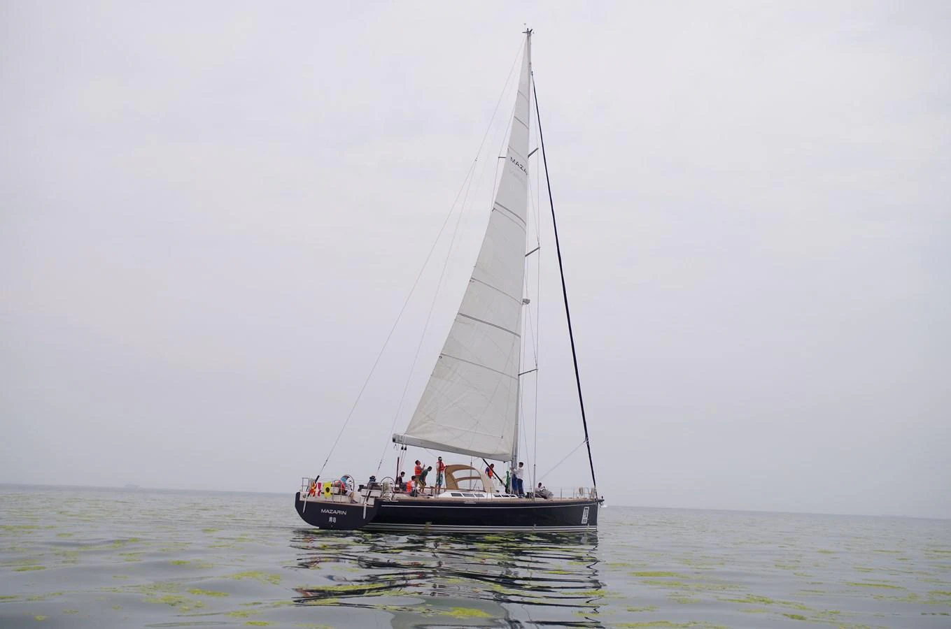 A sleek sailing yacht glides gracefully on calm waters under a cloudy sky. aboard MAZARIN 72 CRUISER RACER Yacht for Sale