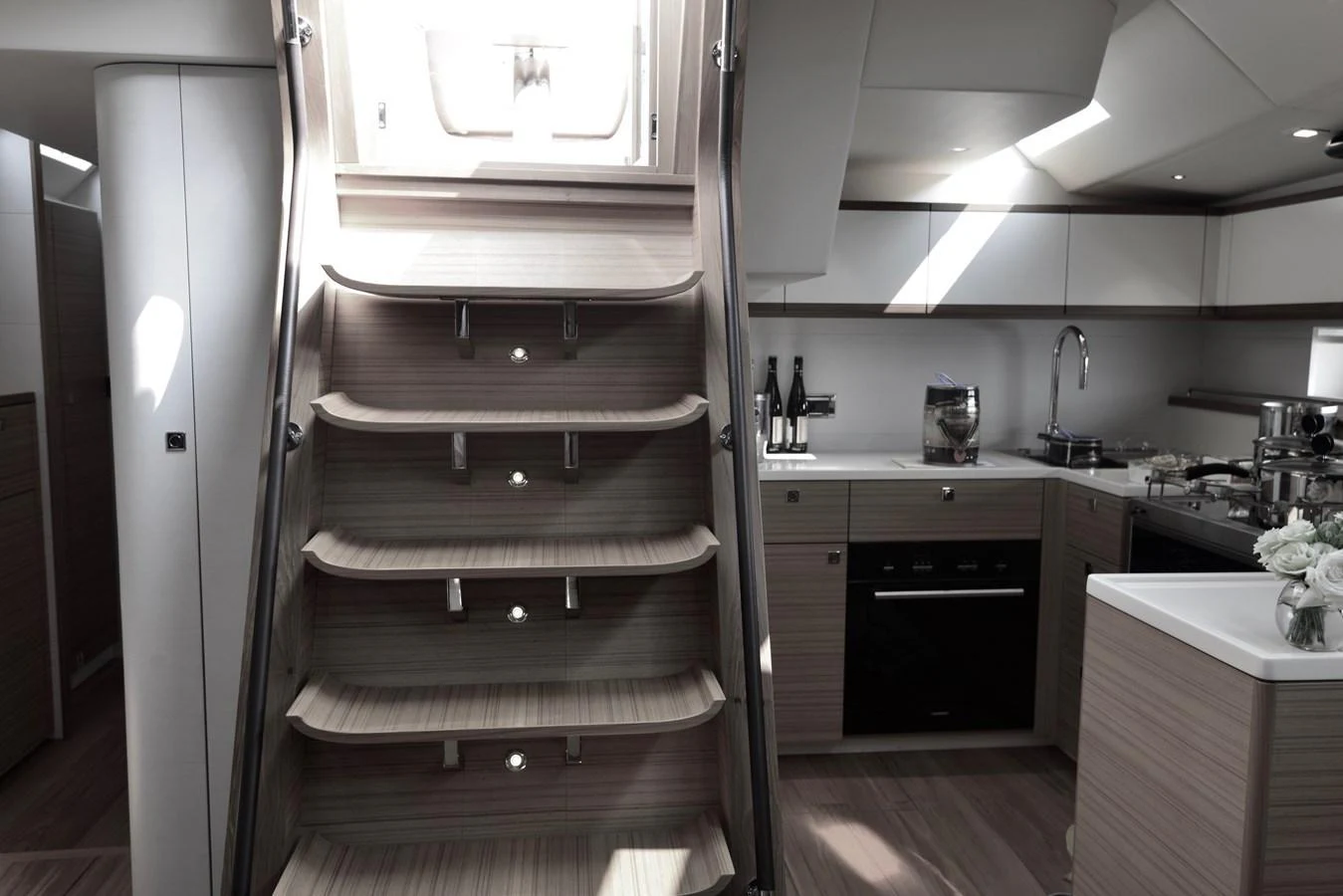 The yacht's galley features modern appliances and a stylish staircase leading to the deck. aboard MAZARIN 72 CRUISER RACER Yacht for Sale