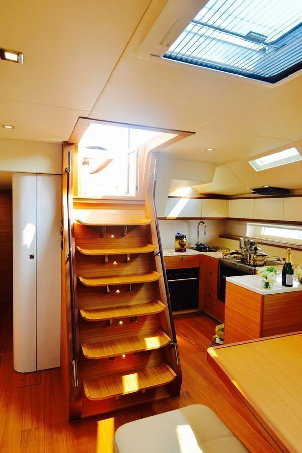 The yacht's galley is bathed in natural light, featuring modern appliances and warm wooden finishes. aboard MAZARIN 72 CRUISER RACER Yacht for Sale