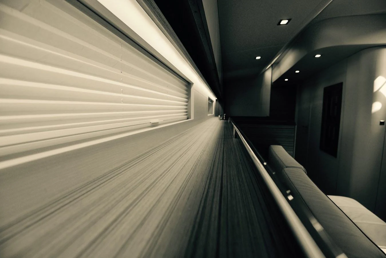A sleek and modern interior space with a long wooden surface and ambient lighting. aboard MAZARIN 72 CRUISER RACER Yacht for Sale
