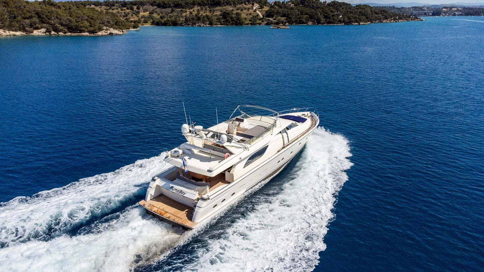 A sleek yacht cruises through clear blue waters, showcasing its elegant design and spacious deck. aboard PUMABAY Yacht for Sale