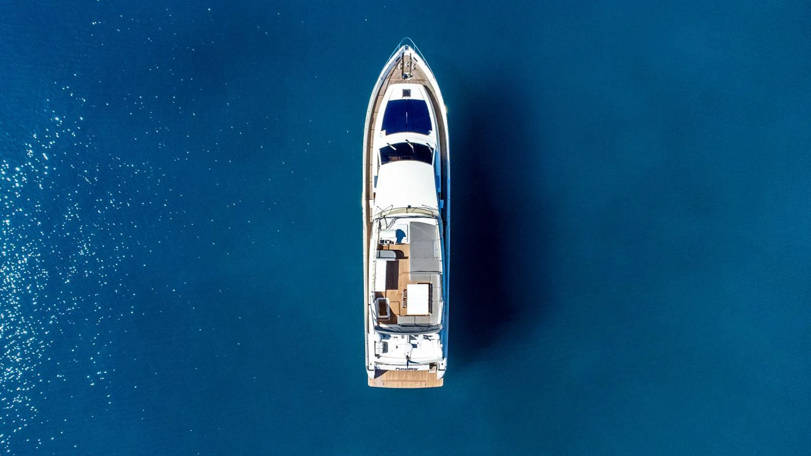 Aerial view of a sleek yacht cruising through calm, deep blue waters. aboard PUMABAY Yacht for Sale