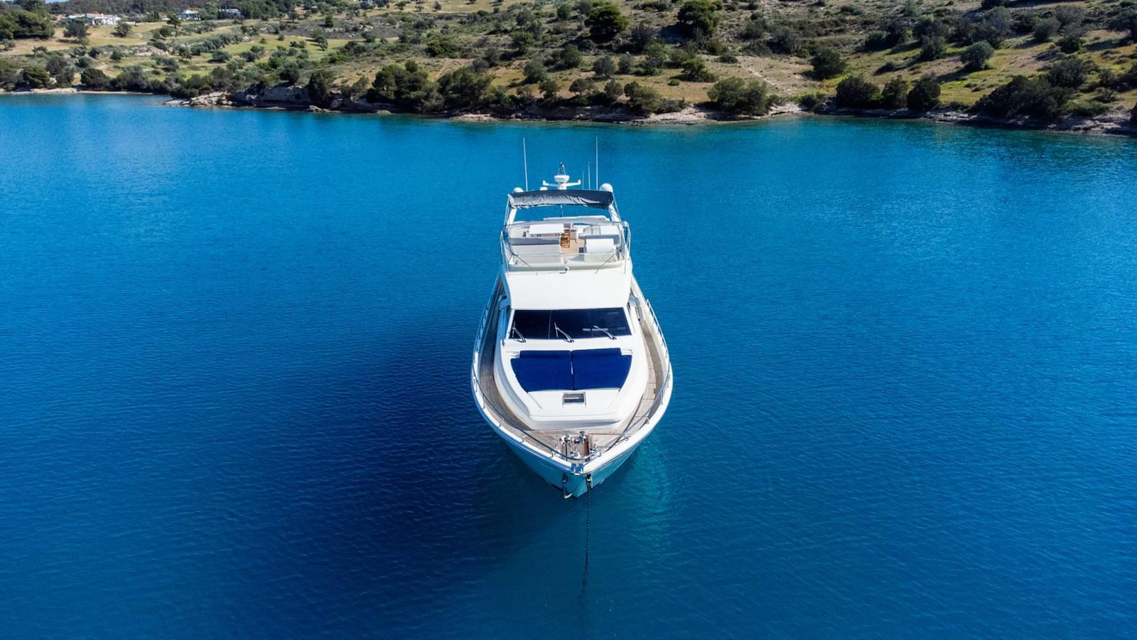 A luxurious yacht anchored in serene blue waters, viewed from the front. aboard PUMABAY Yacht for Sale