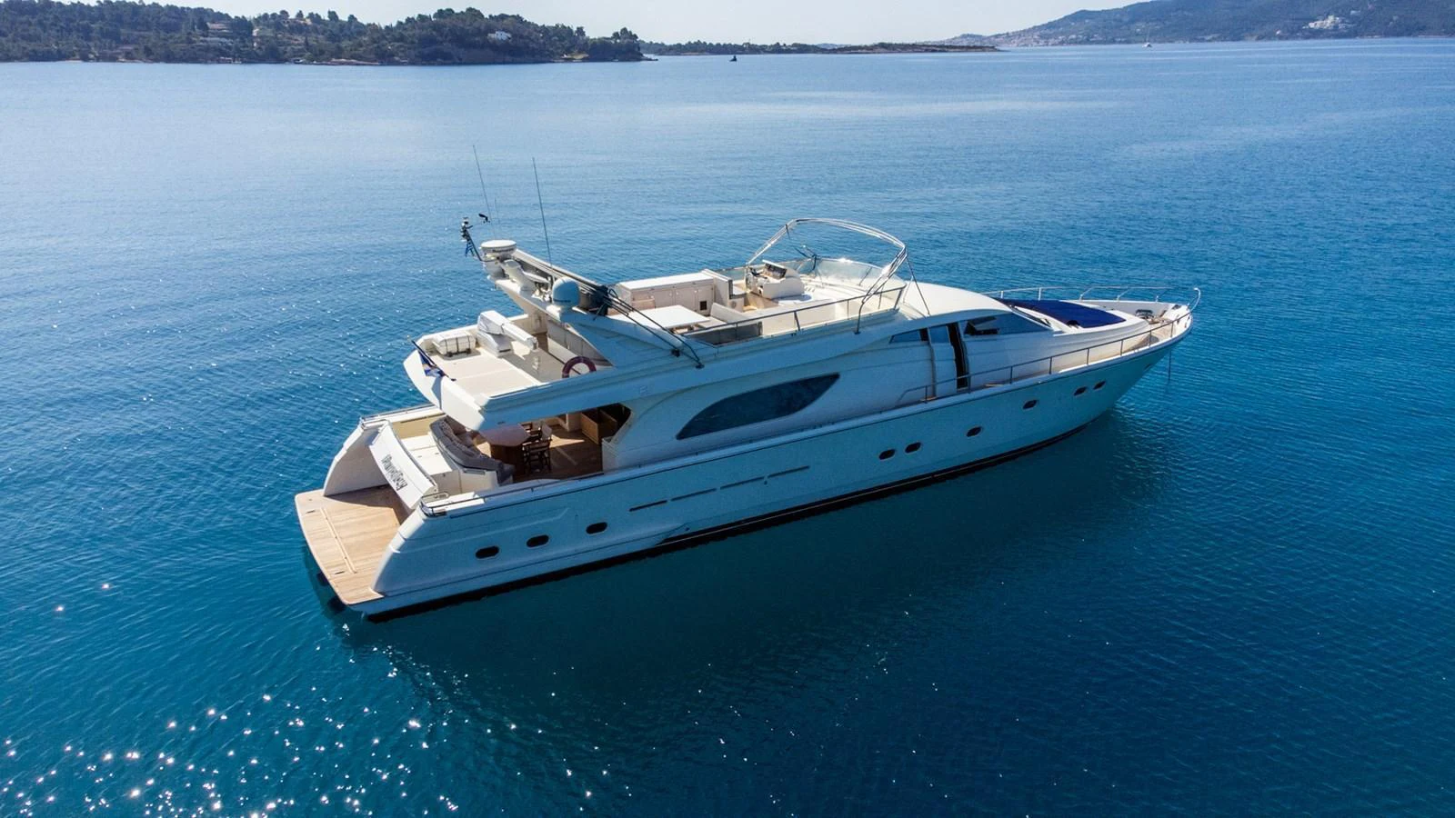 A sleek yacht glides gracefully on calm blue waters, showcasing its elegant design and spacious deck areas. aboard PUMABAY Yacht for Sale