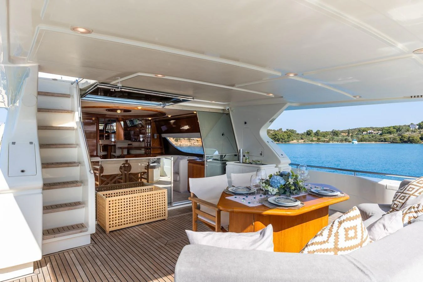 The aft deck features a cozy dining area with a view of the serene waters. aboard PUMABAY Yacht for Sale