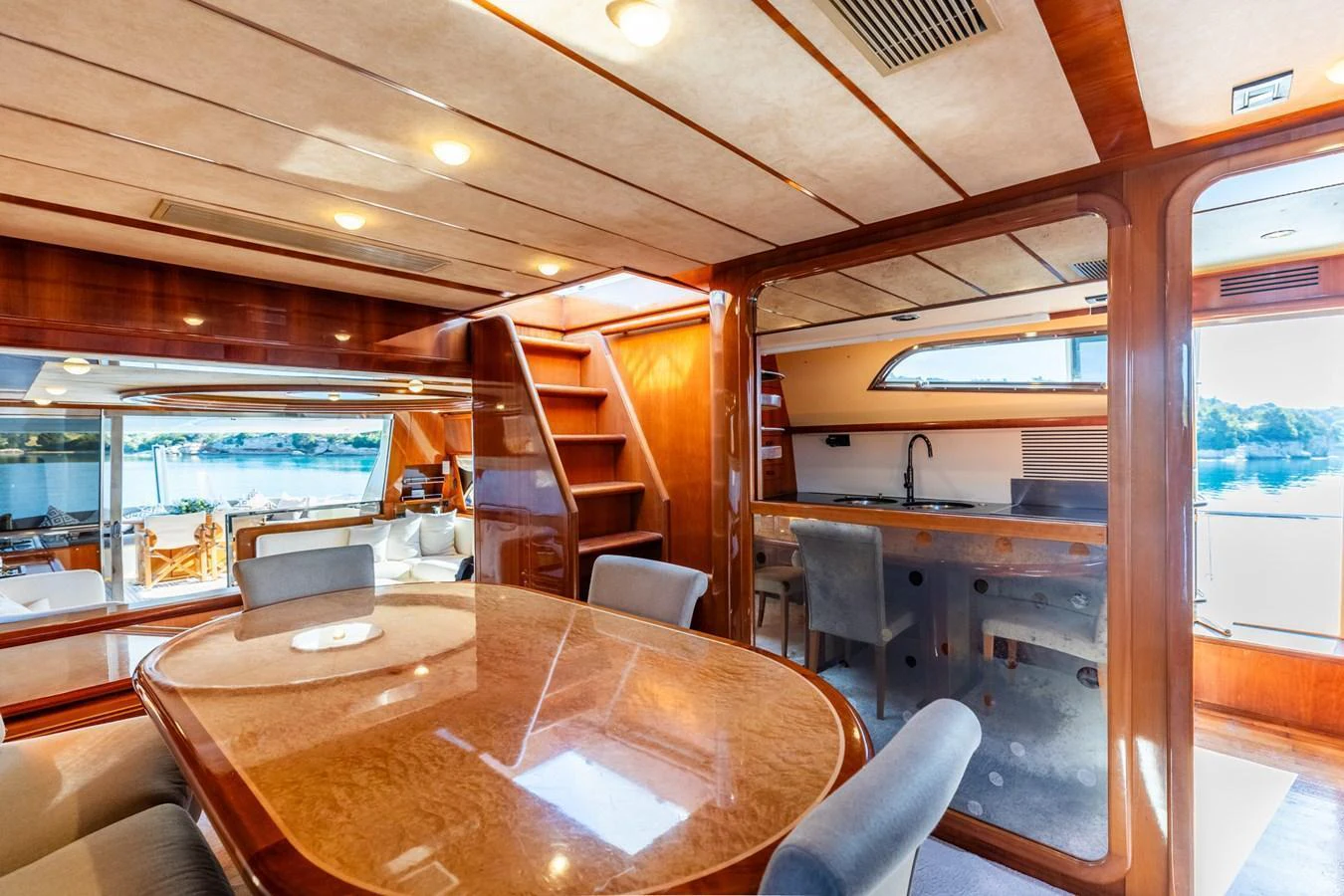 The yacht's dining area features a polished wooden table and comfortable seating with ample natural light. aboard PUMABAY Yacht for Sale