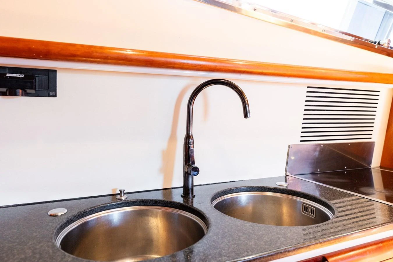 A close-up view of a sleek, modern galley sink area with dual basins and a polished faucet. aboard PUMABAY Yacht for Sale