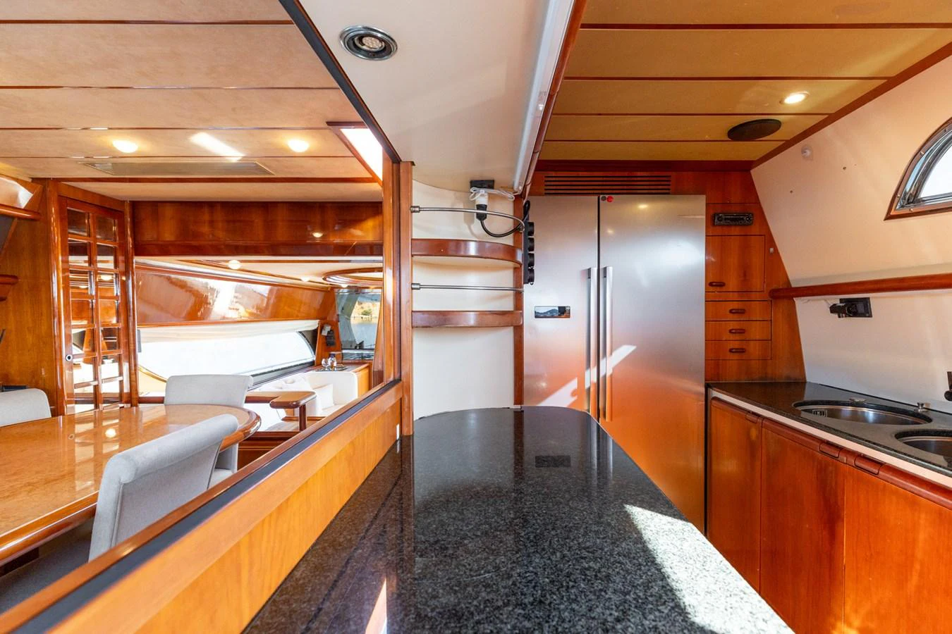 The yacht's galley features a sleek countertop and modern appliances, seamlessly blending with the warm wooden interior. aboard PUMABAY Yacht for Sale