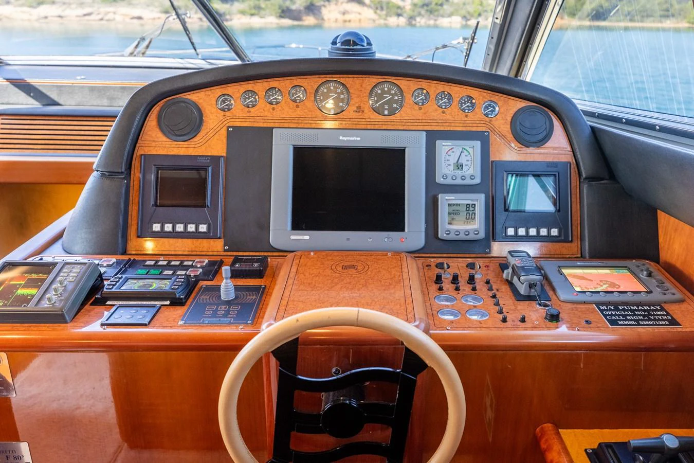 The helm station features a sophisticated array of navigation and control instruments set in a polished wooden console. aboard PUMABAY Yacht for Sale