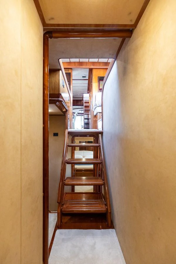A cozy interior stairway with wooden steps and warm lighting. aboard PUMABAY Yacht for Sale