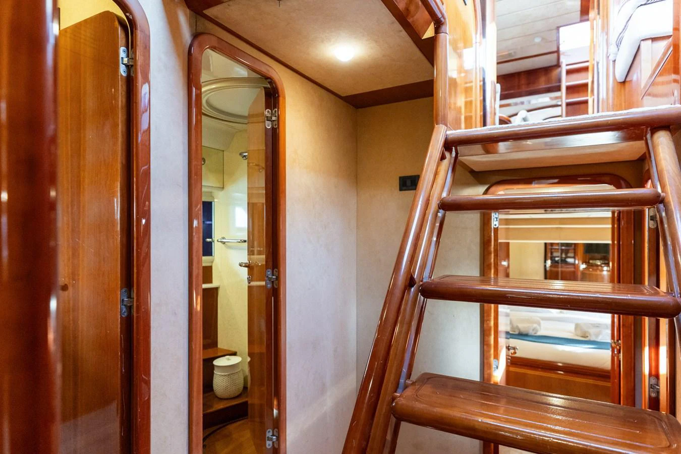 The image showcases a well-crafted interior stairway with polished wood finishes and a cozy ambiance. aboard PUMABAY Yacht for Sale
