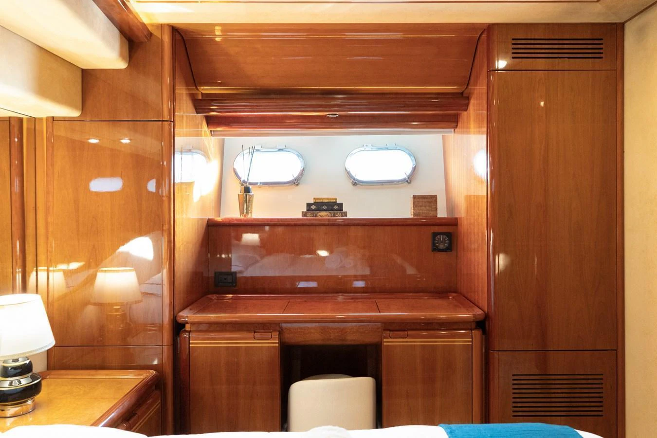 The stateroom features elegant wood paneling and a cozy desk area with natural light from portholes. aboard PUMABAY Yacht for Sale