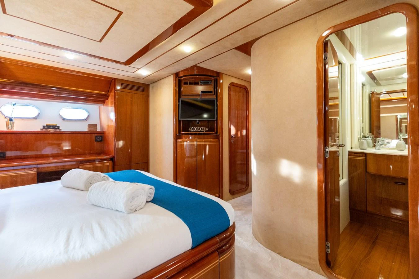 A luxurious stateroom featuring a plush bed, elegant wood finishes, and an en-suite bathroom. aboard PUMABAY Yacht for Sale