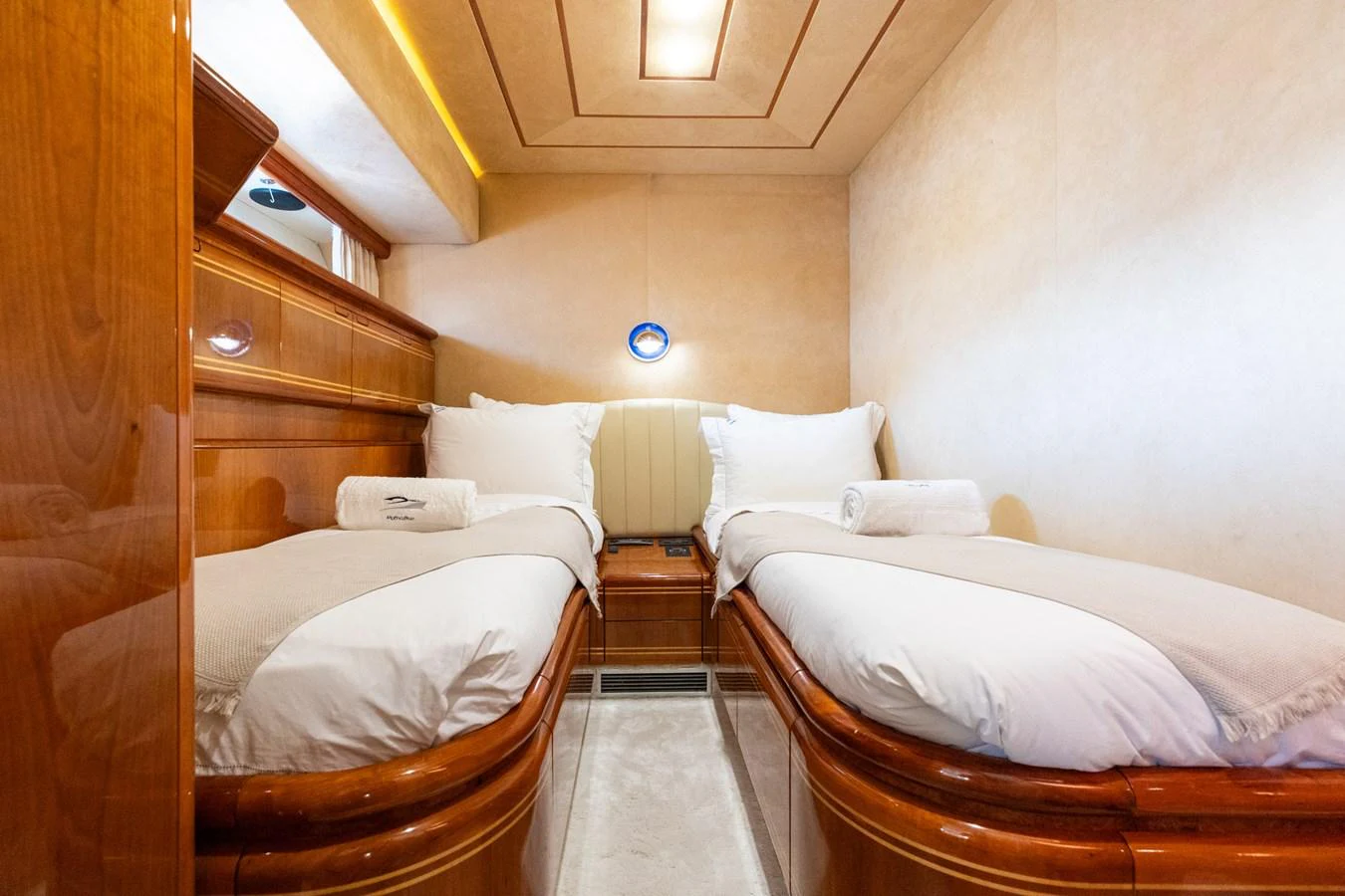 This cozy twin stateroom features elegant wood finishes and plush bedding for a comfortable stay. aboard PUMABAY Yacht for Sale