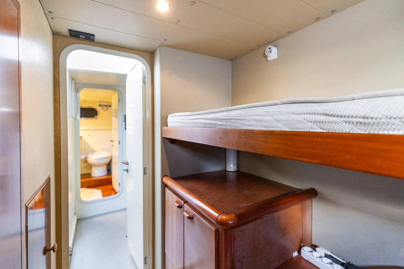 The image showcases a compact crew cabin with a bunk bed and storage, leading to an en-suite bathroom. aboard PUMABAY Yacht for Sale