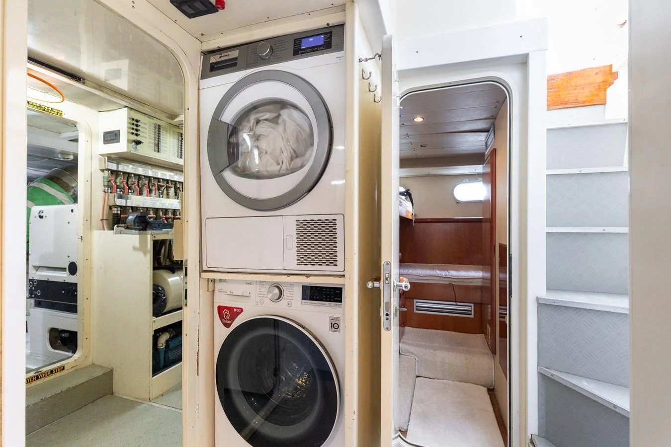 This image showcases the yacht's practical laundry area with a washer and dryer, adjacent to a cozy cabin and engine room. aboard PUMABAY Yacht for Sale