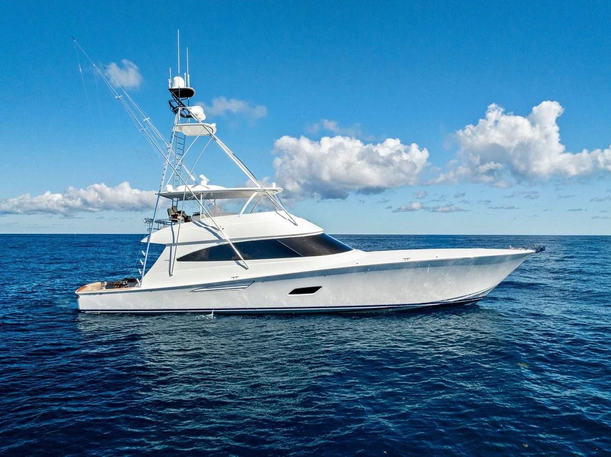 A sleek yacht glides gracefully on the open sea under a clear blue sky. aboard CATCH 23 Yacht for Sale
