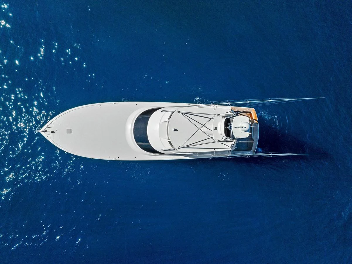 A sleek yacht glides through deep blue waters, viewed from above. aboard CATCH 23 Yacht for Sale