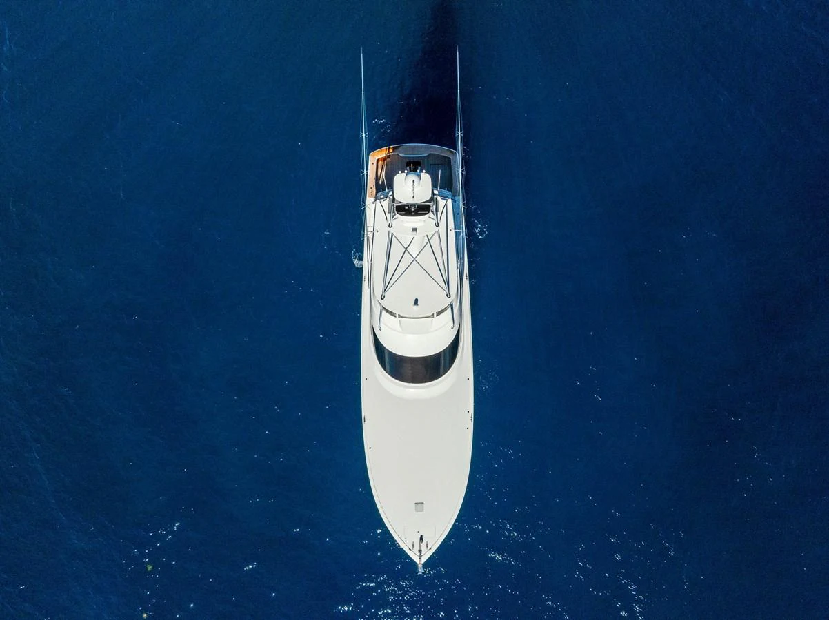 An aerial view of a sleek yacht cruising through deep blue waters. aboard CATCH 23 Yacht for Sale