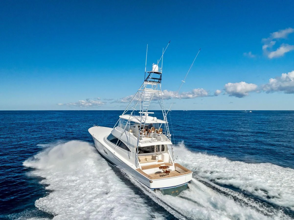 A sleek yacht cruises swiftly through the open sea, leaving a trail of white water behind. aboard CATCH 23 Yacht for Sale