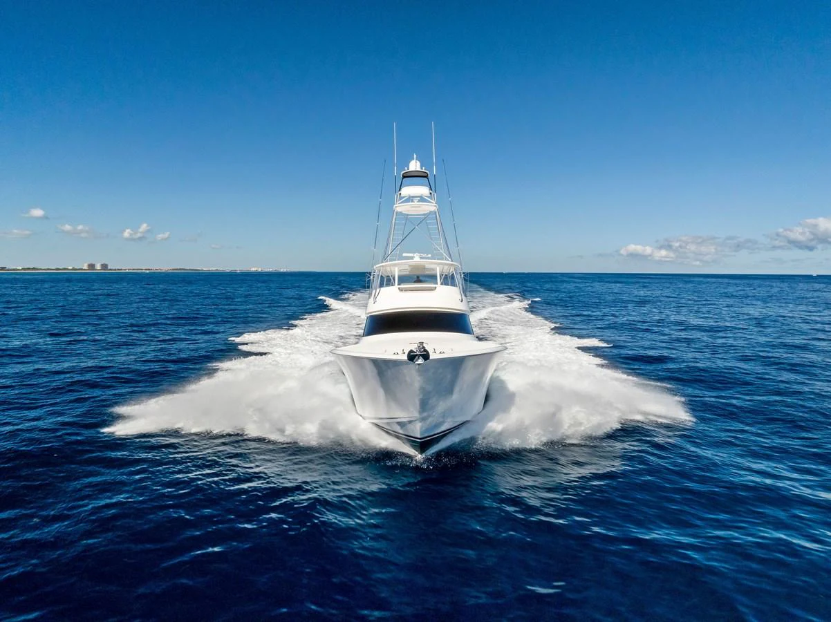 A sleek yacht cuts through the open sea, showcasing its powerful performance. aboard CATCH 23 Yacht for Sale