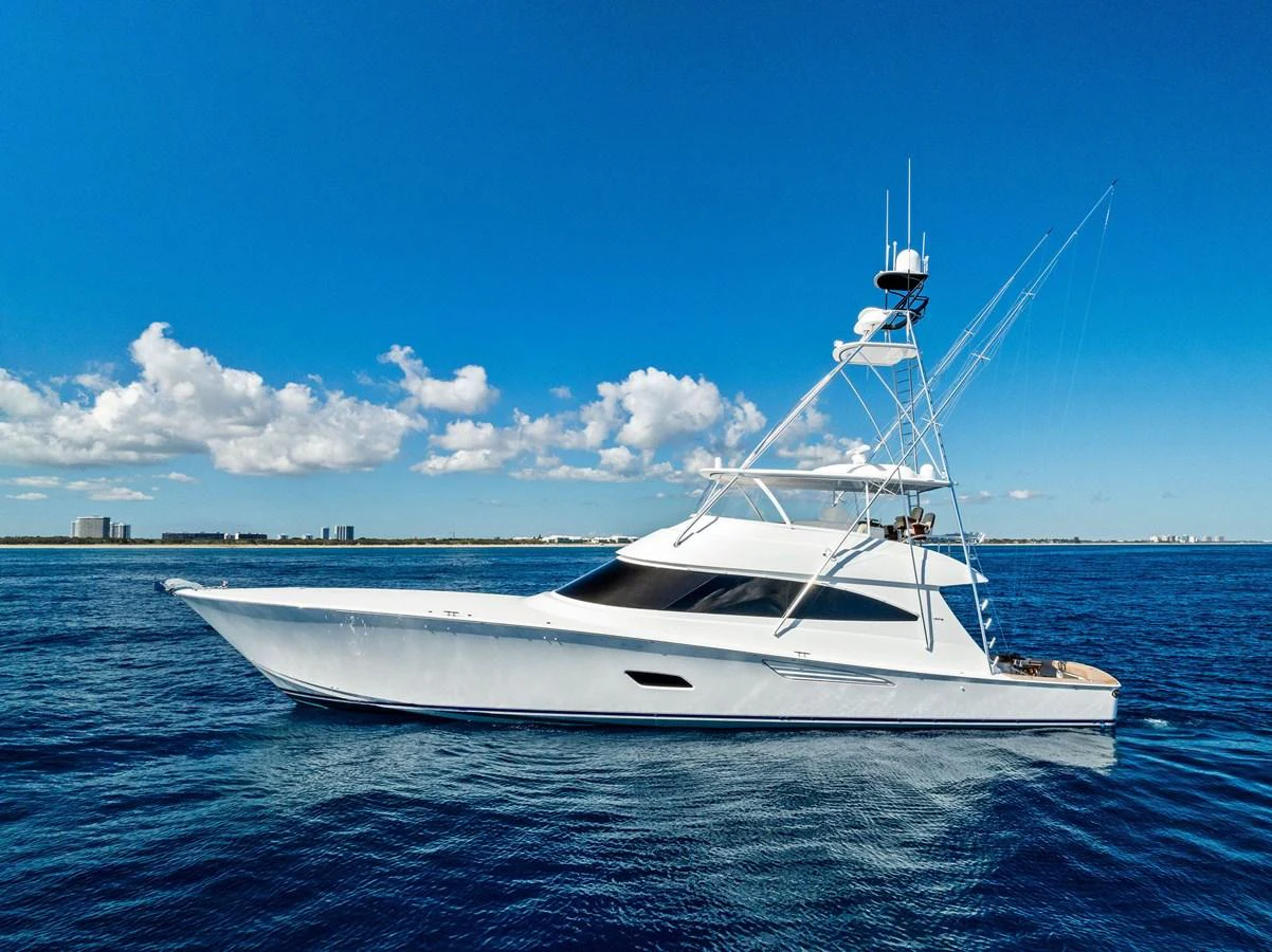 A sleek yacht glides gracefully on calm blue waters under a clear sky. aboard CATCH 23 Yacht for Sale