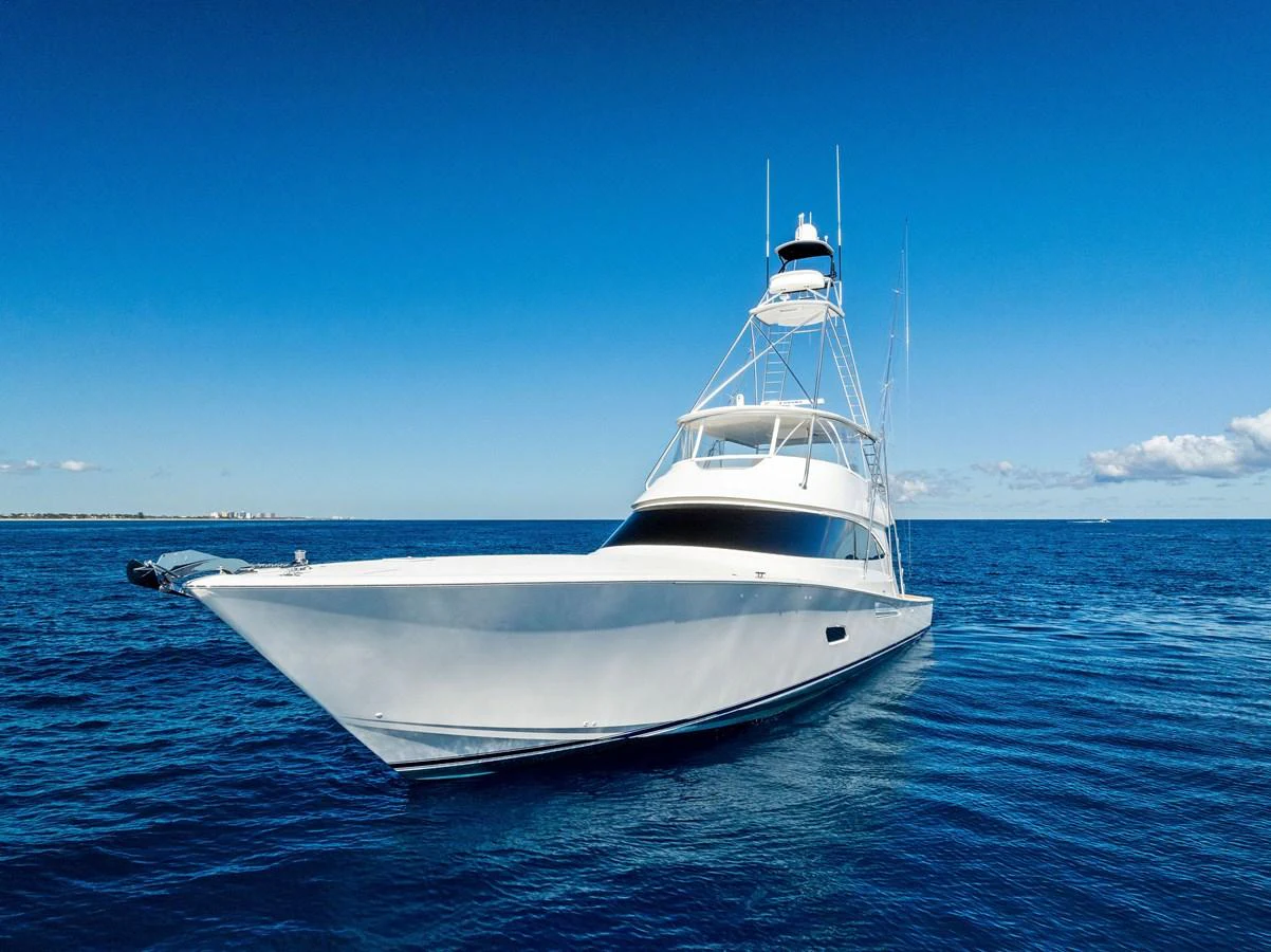 A sleek yacht glides gracefully on the open sea under a clear blue sky. aboard CATCH 23 Yacht for Sale
