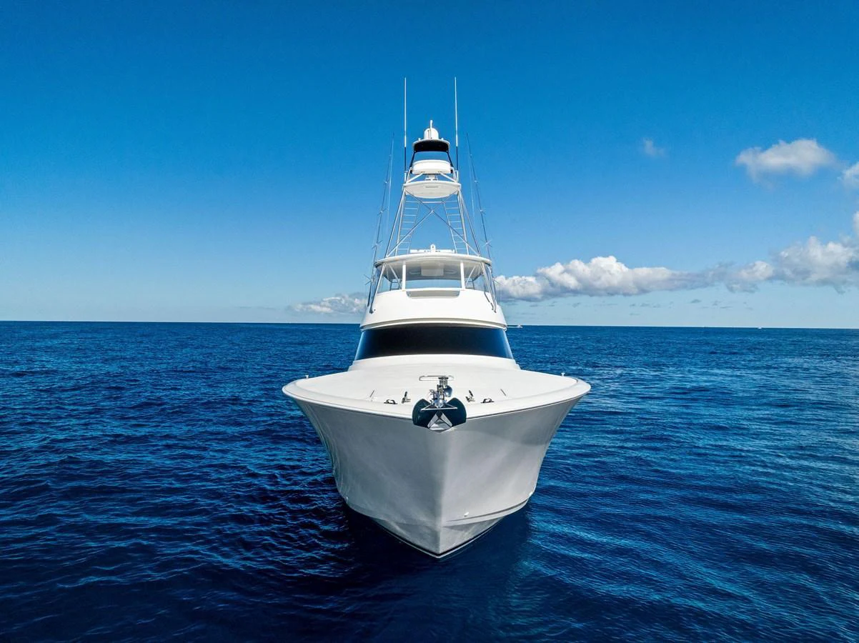 A sleek yacht cruises on open blue waters under a clear sky. aboard CATCH 23 Yacht for Sale
