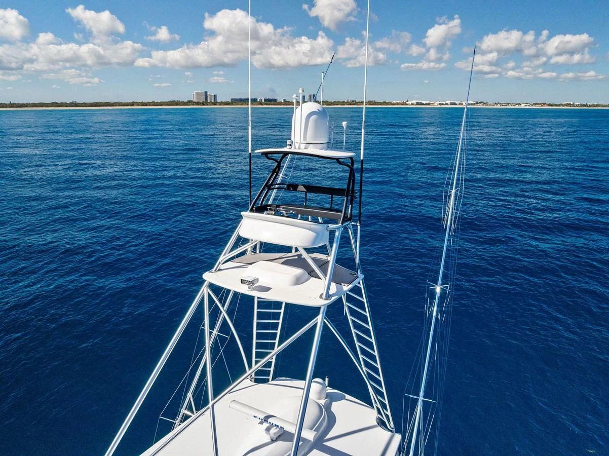 The yacht's flybridge offers a commanding view of the open sea under a clear blue sky. aboard CATCH 23 Yacht for Sale