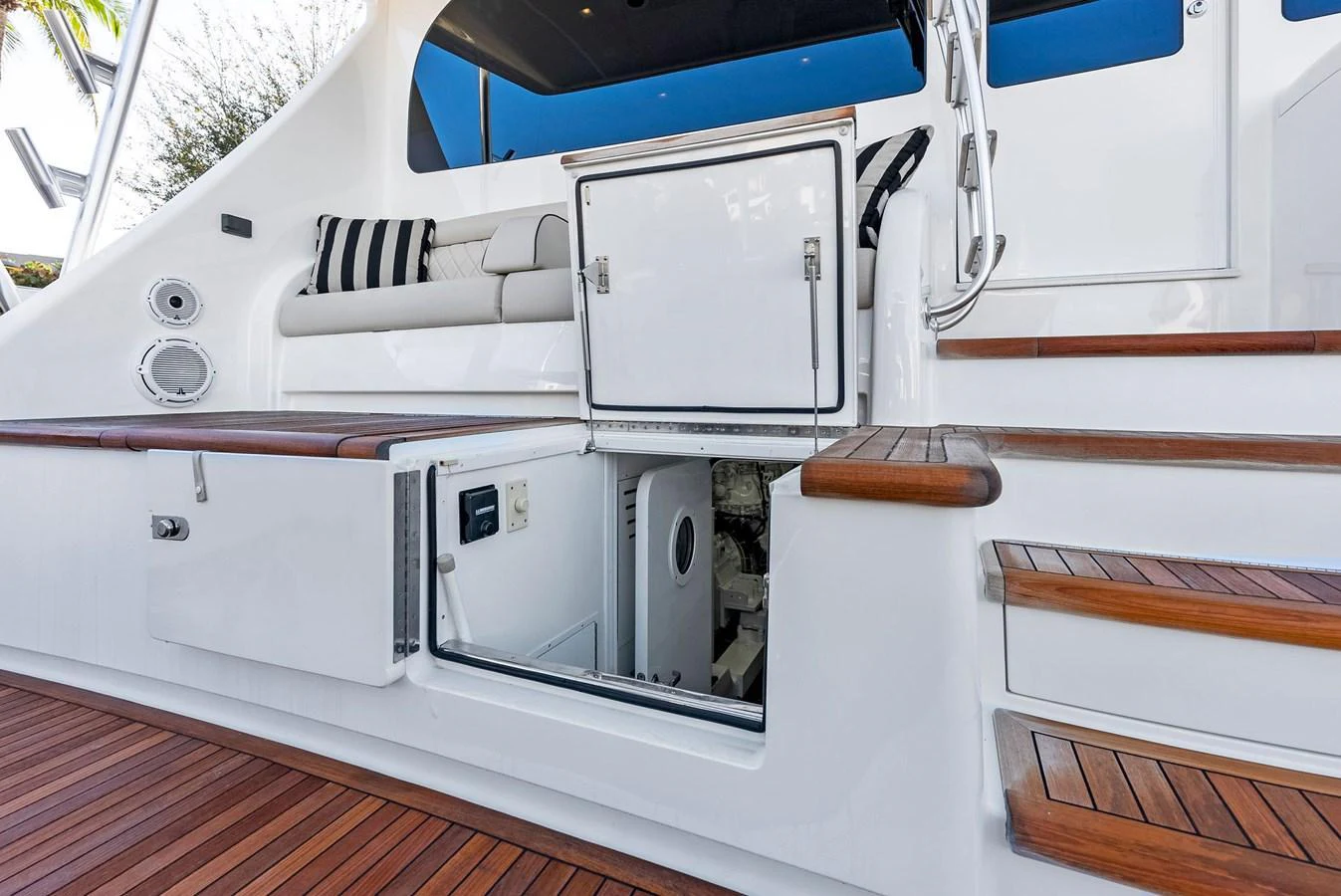 The image showcases a detailed view of the yacht's deck area with storage compartments and wooden steps. aboard CATCH 23 Yacht for Sale