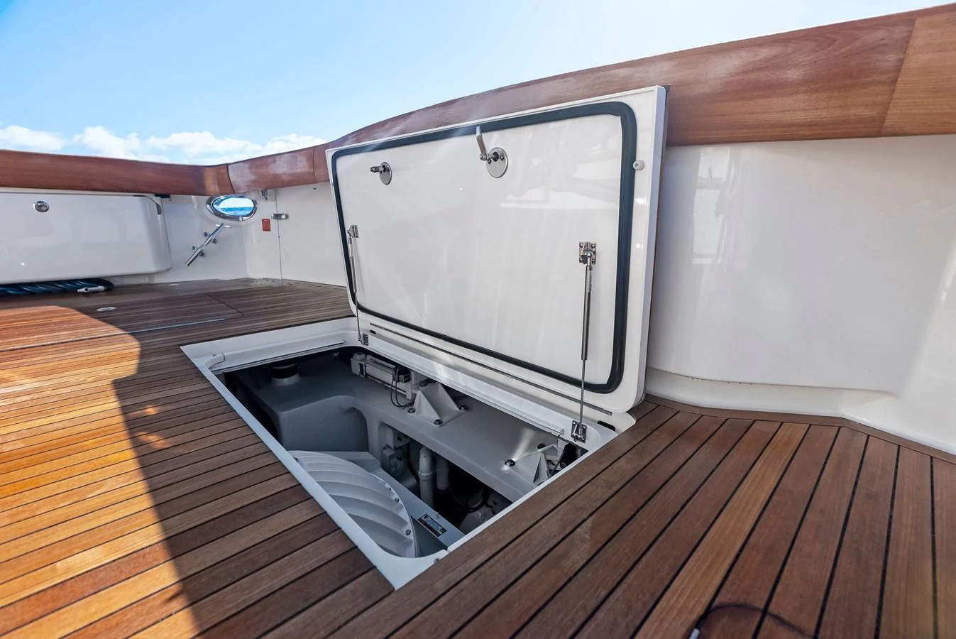 The image showcases an open engine hatch on the yacht's deck, revealing the mechanical components below. aboard CATCH 23 Yacht for Sale