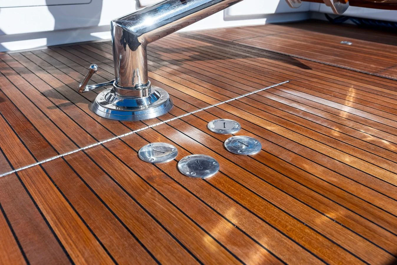 A close-up view of the yacht's polished teak deck with stainless steel fittings. aboard CATCH 23 Yacht for Sale