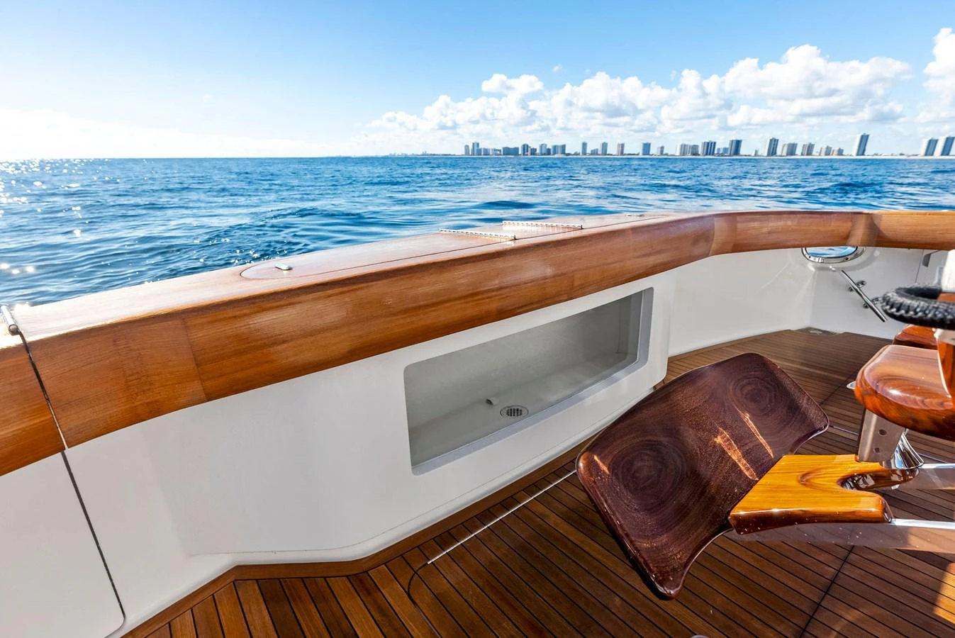 The aft deck offers a serene view of the ocean with a polished wooden finish and comfortable seating. aboard CATCH 23 Yacht for Sale