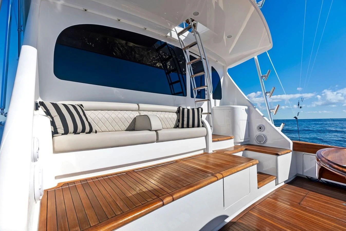 The aft deck features comfortable seating with stylish cushions and a beautiful wooden deck, perfect for relaxation. aboard CATCH 23 Yacht for Sale