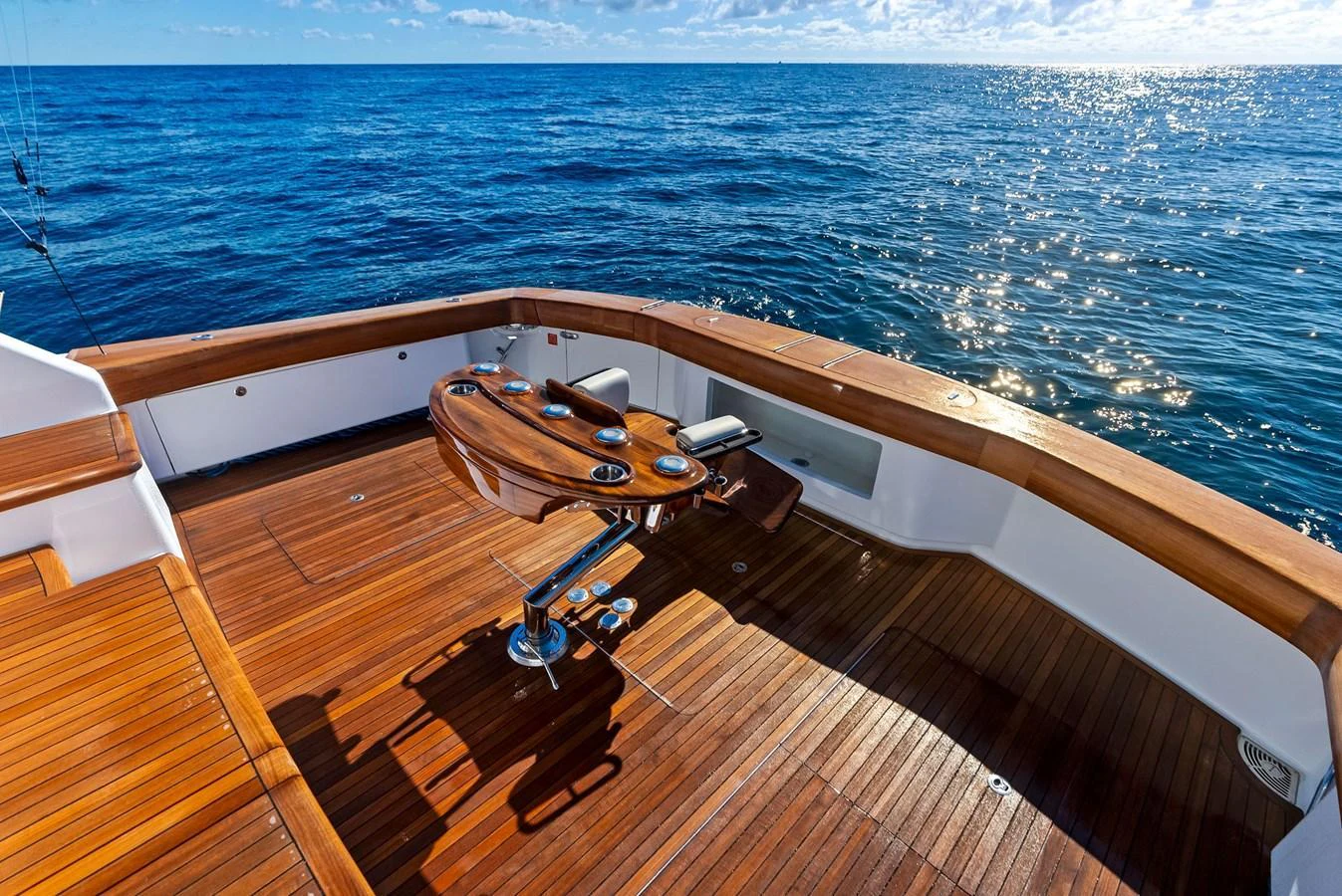 The aft deck features a beautifully crafted wooden table and seating area, perfect for enjoying the open sea views. aboard CATCH 23 Yacht for Sale