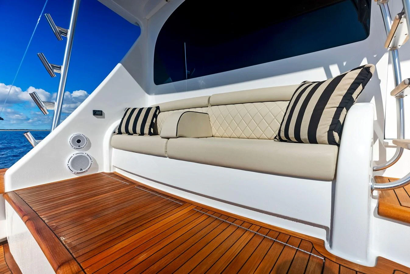 The aft deck features a comfortable seating area with plush cushions and a beautiful wooden floor. aboard CATCH 23 Yacht for Sale