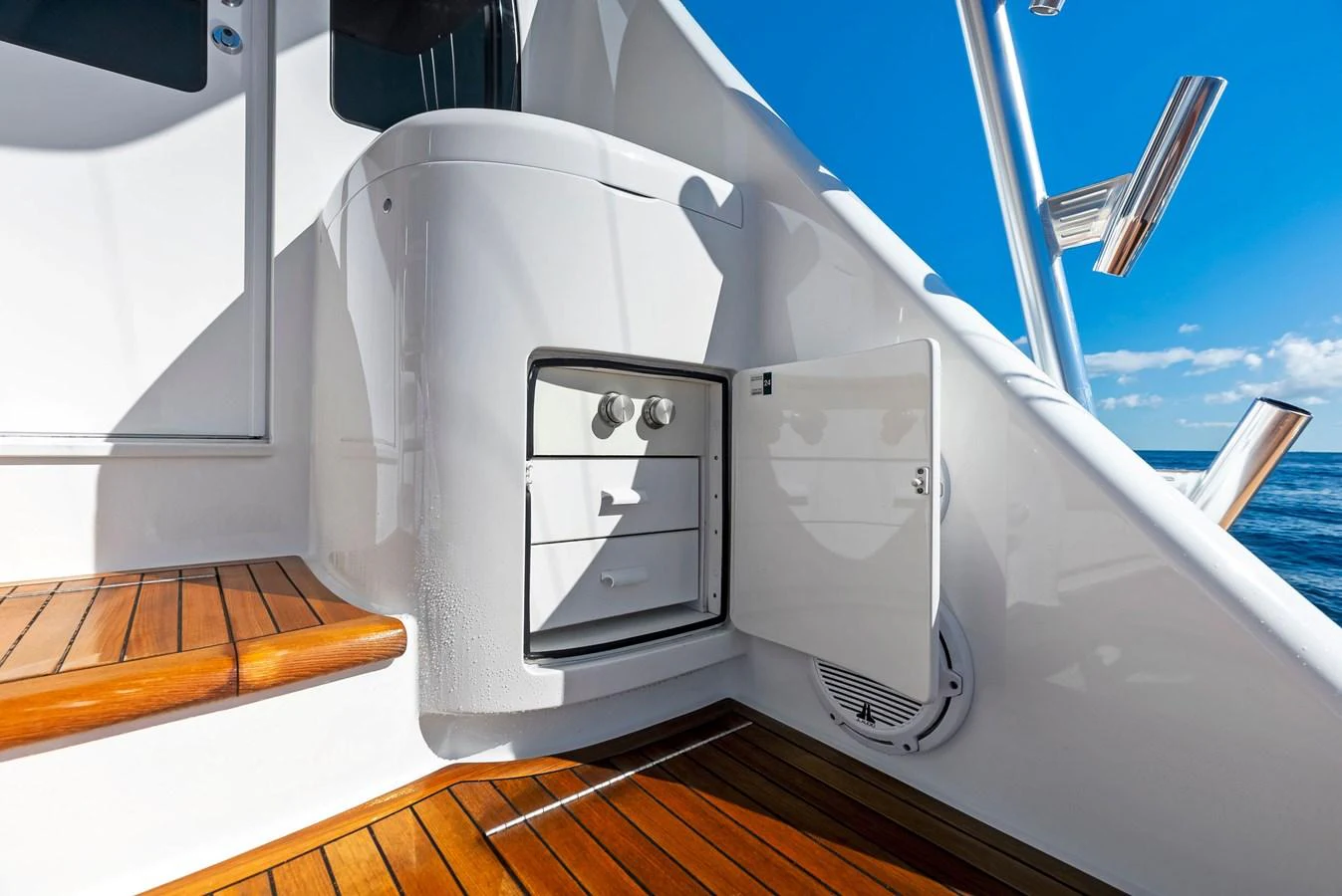 A sleek and modern outdoor storage compartment on the yacht, with polished wooden decking and a bright, sunny backdrop. aboard CATCH 23 Yacht for Sale