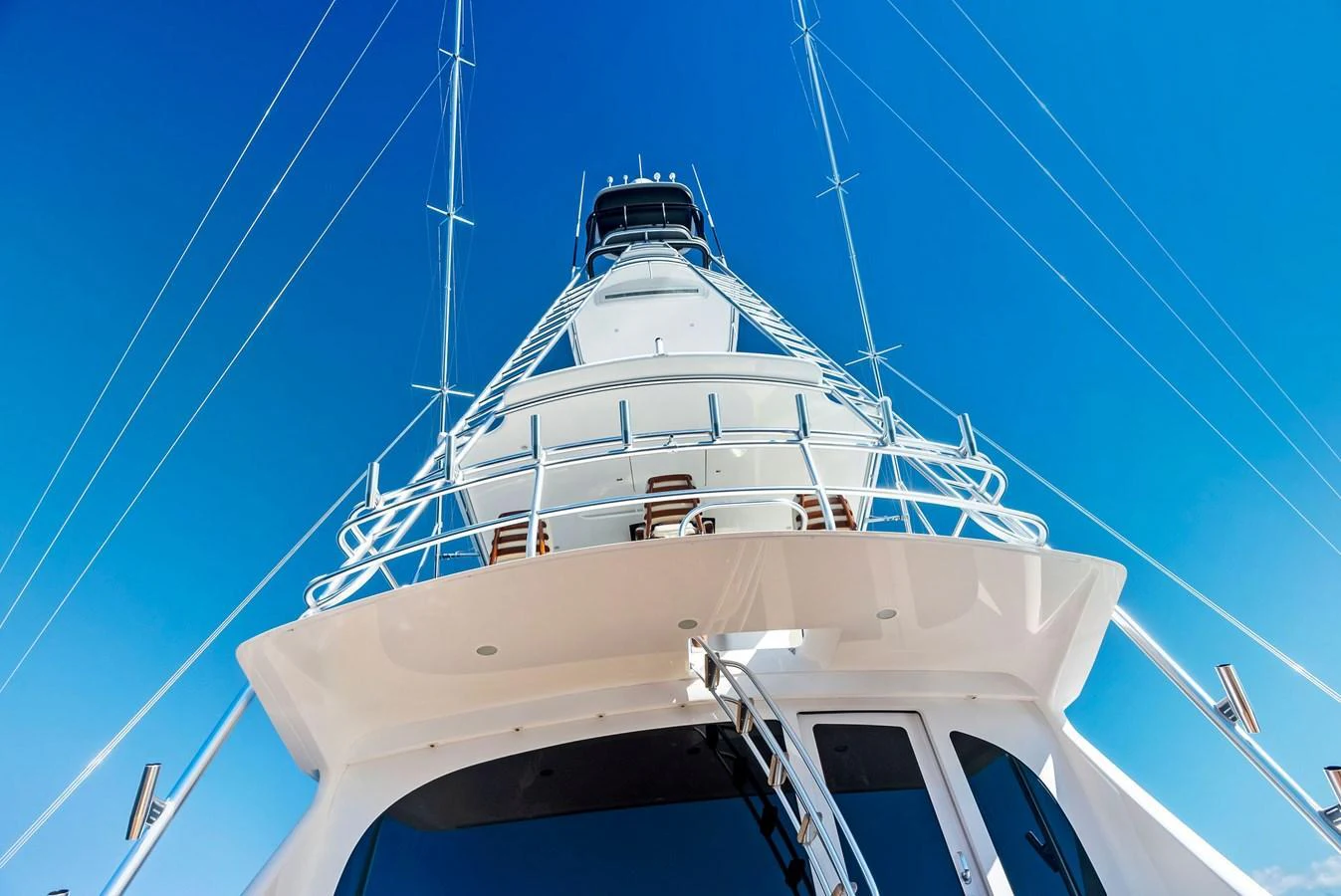 A striking view of the yacht's towering structure against a clear blue sky. aboard CATCH 23 Yacht for Sale