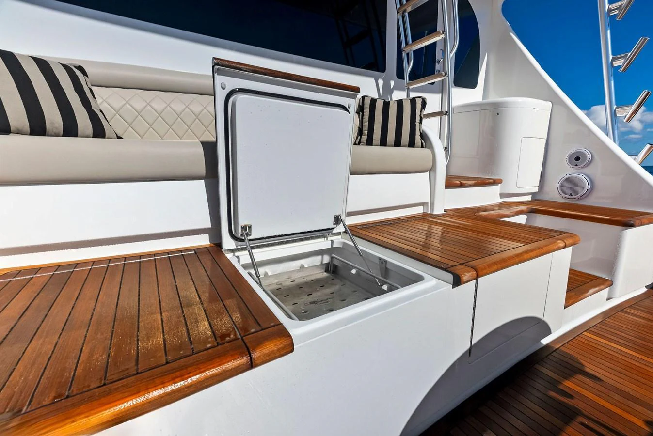 The image showcases a yacht's deck area with a built-in cooler and comfortable seating. aboard CATCH 23 Yacht for Sale